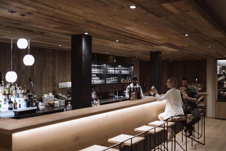 A couple sits at the bar with a drink.